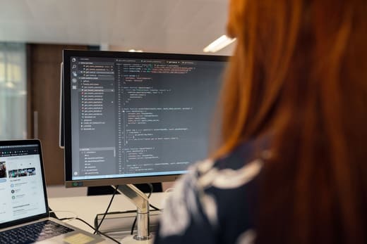 An analyst writing code at a workstation
