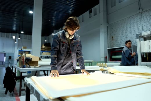 A factory worker checking printed production sheets