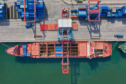 A container ship at a port terminal from above, for customs broker pay