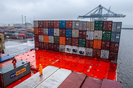 Dock workers on a loaded container ship, for logistician pay